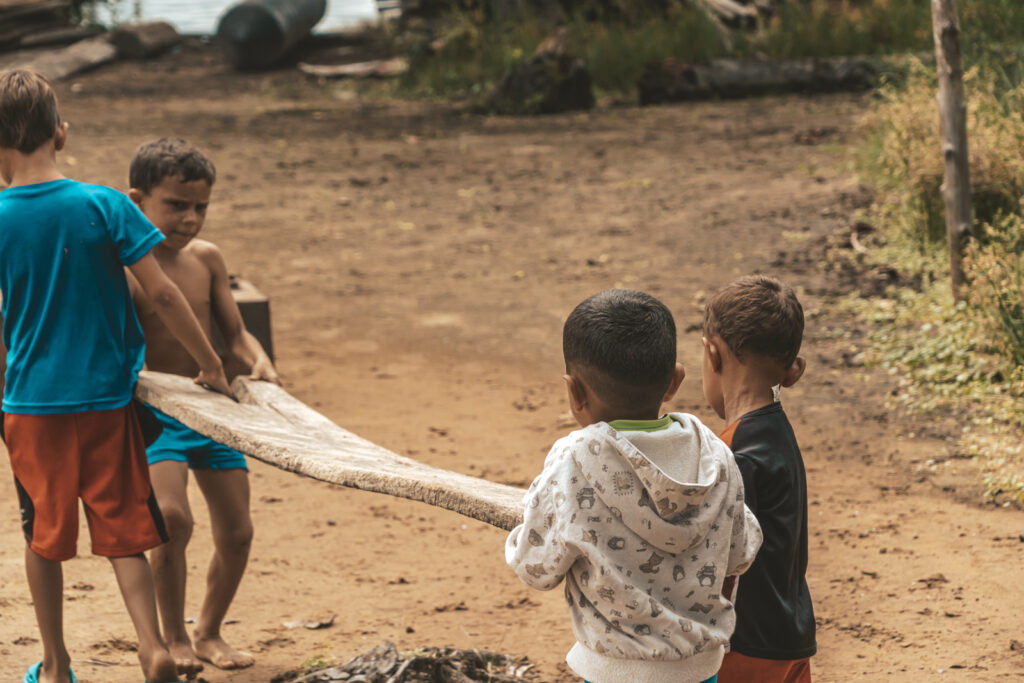 Niños de Ologá, en el lago de Maracaibo (Zulia), jugando con un pedazo de tabla de madera. Foto: Aldenix David Ocanto.
