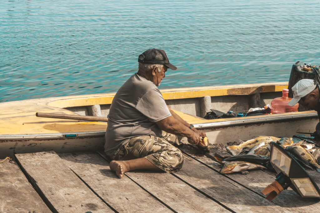 Nerio Ángel Romero, conocido como Tani, limpiando los pescados que le llevaron despuésde la faena del día. Foto: Aldenix David Ocanto